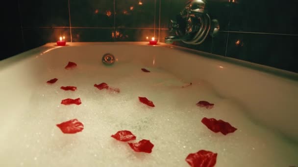 Bañera romántica con pétalos de flores y velas rojas — Vídeos de Stock