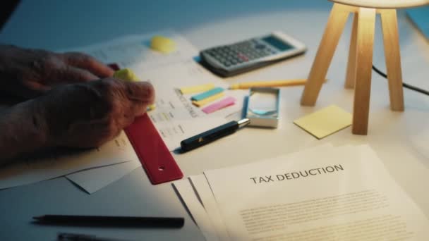 Man is doing the tax deduction of taxes on the table at home — Stock Video
