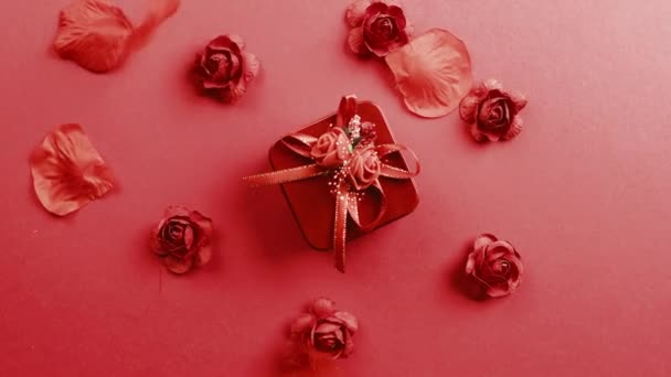 Rood geschenk met bloemblaadjes naar beneden vallen op de achtergrond — Stockvideo
