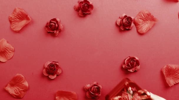 Rotes Geschenk mit Blütenblättern, die auf den Hintergrund fallen — Stockvideo