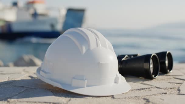 White engineer helmet and binoculars in a naval port — Stock Video