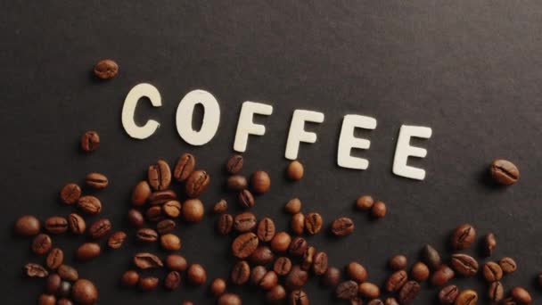 Coffe text on black background and coffee beans — стоковое видео