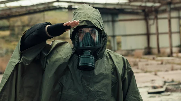 Människan hälsar med gasmask i en byggnad förstörd av krig — Stockfoto