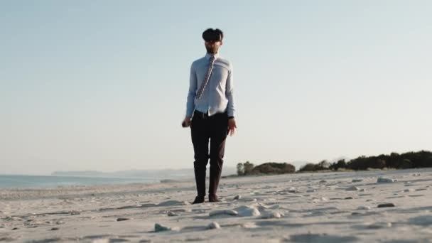 Business guy doet sport op het strand met virtual reality headset en shirt — Stockvideo
