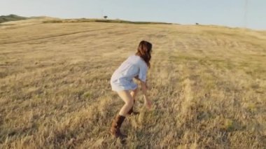 İtalyan kız kırsalda buğday tarlasında dans ediyor.