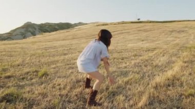 İtalyan kız kırsalda buğday tarlasında dans ediyor.