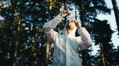 Dağ biyoloğu nesli tükenmekte olan bitkiler için test tüpünü analiz ediyor..