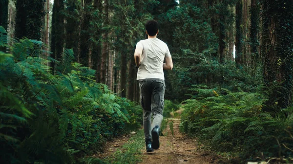 Boy trains by running on a trail in the mountains at night.