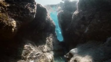snorkeling between the rocks in the mediterranean sea.
