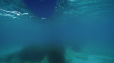 Oar of stand up paddle seen from underwater in the sea.