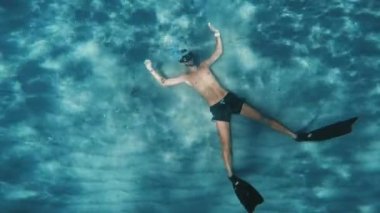Young boy does freediving underwater in the ocean.