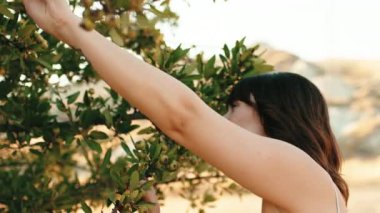 Young girl has fun in the countryside near a tree in the nature in Summer.