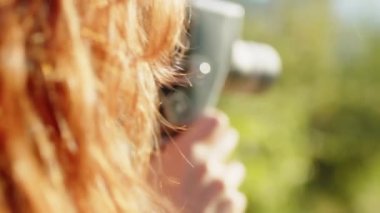 Young photographer girl shoots video with vintage film camera