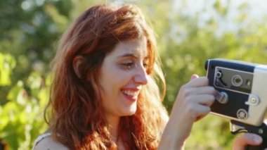Young photographer girl shoots video with vintage film camera