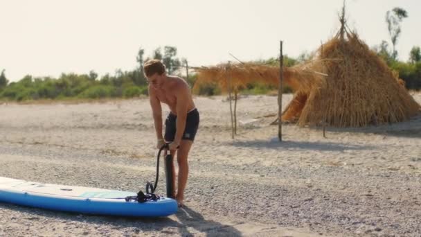 Хлопчик Надуває Дошку Влітку Пляжі — стокове відео