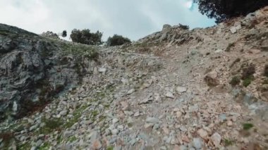 Kuru bir dağın tepesinde taşlar ve gri topraklar.