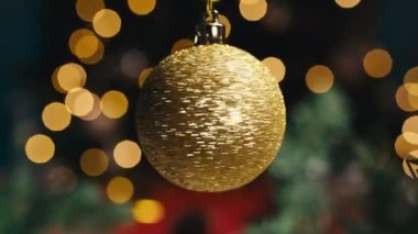 Noel ağaçta dönen altın renkli top.
