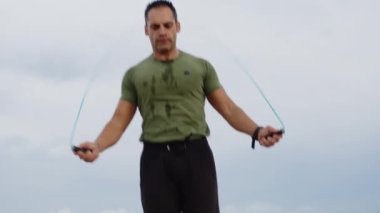 Adam yağmurlu ve bulutlu bir günde dışarıda spor antrenmanı yapıyor..