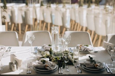 Mumlar ve beyaz çiçeklerle süslenmiş düğün masası