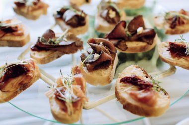 Yemek masası, farklı atıştırmalıklar ve sandviçli aperatifler.