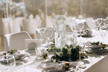 Mumlar ve çiçeklerle dolu bir restoranda şenlikli bir düğün masasının zarif dekorasyonu.