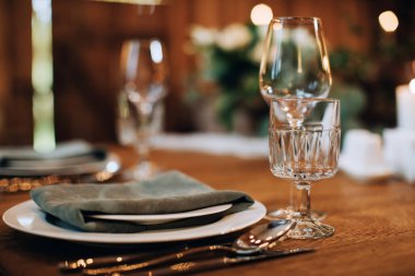 Ahşap bir masada boş şarap kadehleri. Şenlikli yemek masası dekorasyonu