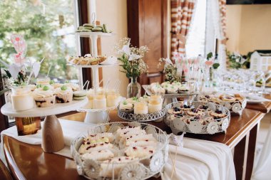 Çeşitli tatlılarla dolu bir masa. Kurabiyeler, çikolatalar, pastalar, ekler-