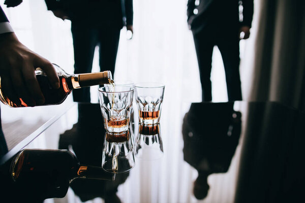 Barman pouring whiskey whiskey glass for friends in restaurant