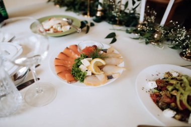 Restoranda bir tatil masasında tabakta çeşitli balıklar. Farklı bayram yemekleri.