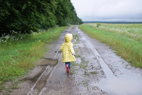 Seorang Anak Kecil Dalam Mantel Hujan Kuning Berjalan Jalan Tanah — Stok Foto