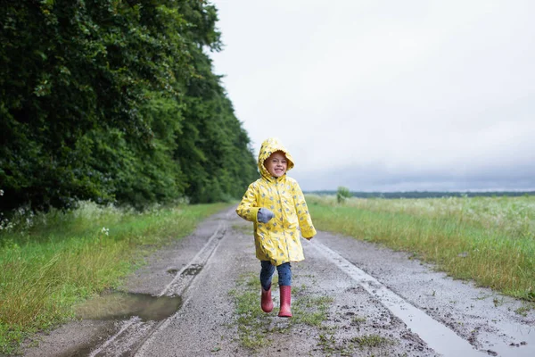 Gadis Kecil Dengan Jas Hujan Kuning Berjalan Jalan Tanah Dengan — Stok Foto