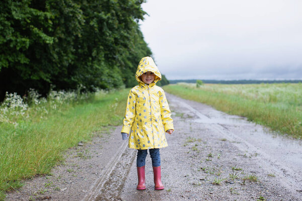 Happy Child Yellow Raincoat Walks Rain Country Road Royalty Free Stock Images