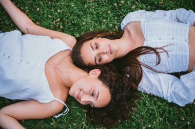 Onlar dinlenirken iki rahat kız parkta çimlere uzanıyorlar.