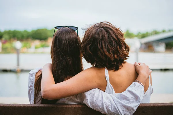 Pohled Zezadu Dva Dospívající Přátele Sedící Lavičce Když Objímají — Stock fotografie