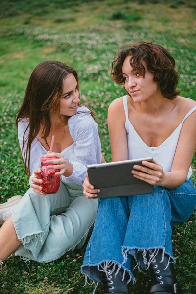 Dva Přátelé Sebe Dívají Zatímco Kontrolují Sociální Média Tabletu Sedí — Stock fotografie