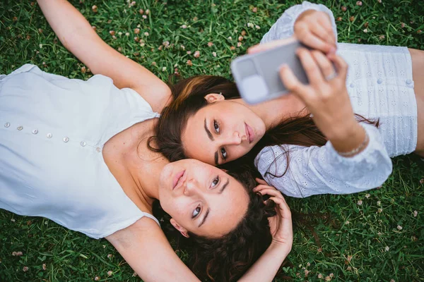 Dvě Puberťačky Dávají Fotku Sociální Média Leží Trávě Parku — Stock fotografie