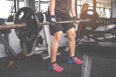 Spor salonunda halterle eğitime başlayan genç adam. Fitness kaslı vücut. Fitness konsepti. Egzersiz konsepti