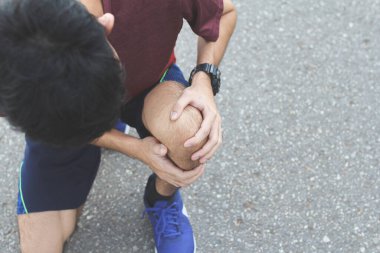 Spor yaparken acı çeken sporcuya yakın koşudan sonra diz sakatlığı. Antrenman konseptinden dolayı yaralanma..