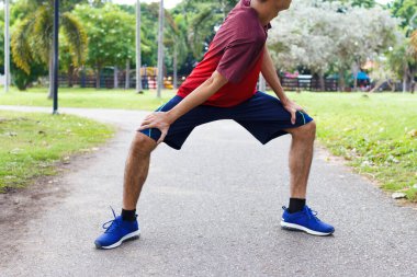 Genç adam koşudan önce ısınır - egzersiz konsepti