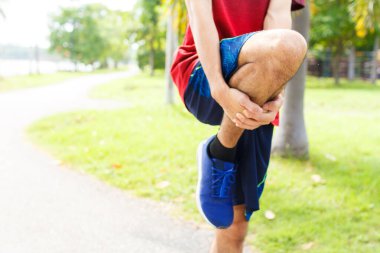 Genç adam koşudan önce ısınır - egzersiz konsepti