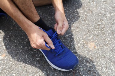 Sporcunun yakın çekimi. Antrenmandan önce spor ayakkabılarını spor ayakkabılarına bağlıyor. Çalışan kavram. çalışma konsepti.