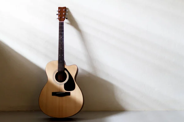 Beyaz duvar arka planında akustik gitar