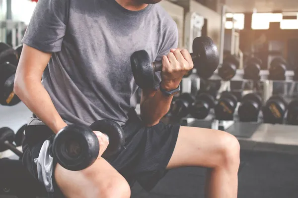 Dambılla egzersiz yapan zayıf bir adamın yakın çekimi. Fitness kaslı vücut. Fitness konsepti
