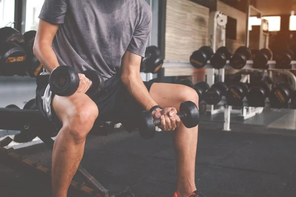 Dambılla egzersiz yapan zayıf bir adamın yakın çekimi. Fitness kaslı vücut. Fitness konsepti