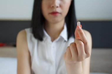 Genç bir kadın hap alıyor, uyuşturucu alıyor. İşteki ilaçlar