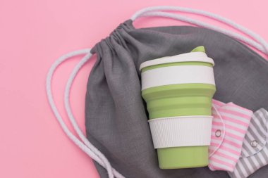 Moda çevre dostu yeniden kullanılabilir bardak. Tekrar kullanılabilir pamuk pedleri. Gri alışveriş çantası. Bilinçli tüketim kavramı. Tek kullanımlık araçlara alternatifler.