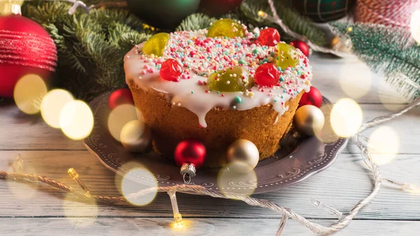 Italienische Weihnachtskuchen mit süßem Dekor und Weihnachtsschmuck, Lichter — Stockfoto