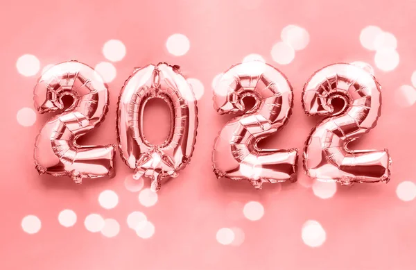 2022 nytt år glänsande folie ballong siffror på rosa bakgrund Stockbild
