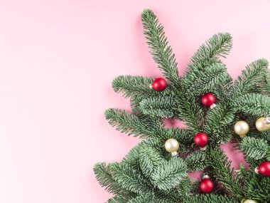 Noel ağacı ladin dalı pembeye kırmızı mücevherlerle süslenmiş.