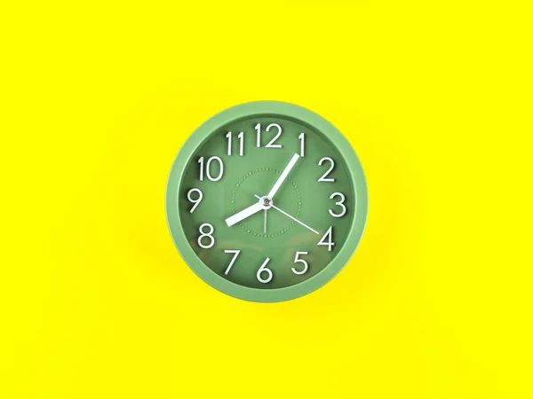 Relógio de alarme verde em fundo amarelo arrojado. Conceito de tempo — Fotografia de Stock
